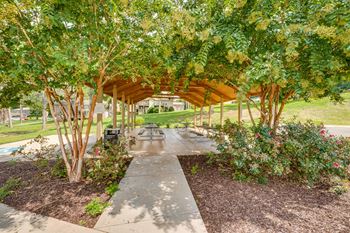 a pavilion with benches and trees in a park